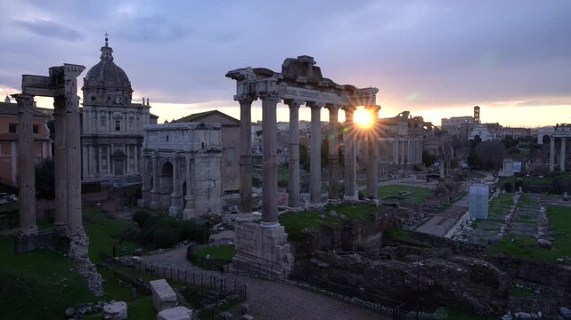 Roman Forum at Sunrise. Epic Sunflare Shines Through Pillars of Ancient Architecture in Rome, Italy, Europe. Travel Tourism.