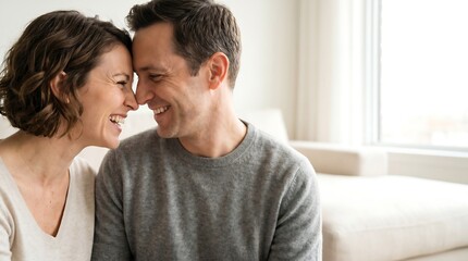 Obraz premium A happy middle-aged couple sharing a tender moment, touching foreheads and smiling warmly at each other.