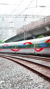 A Fuxing Hao high-speed train speeds through a city.