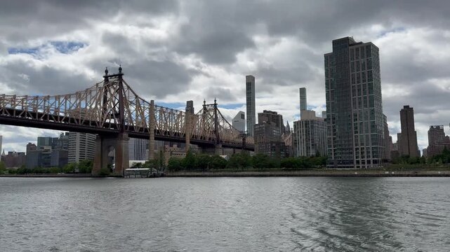 Panoramic, scenic view of Ed Koch Queensboro bridge, Roosevelt island and skyscrapers of East Midtown. Motion of East river. New York City skyline. View from Queensbridge Park
