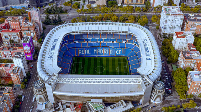 Aerial drone view of Santiago Bernabeu stadium, Real Madrid CF, Madrid, Spain, urban cityscape. Pre-renovation Bernab&eacute;u (open roof, original seating). Post-2023 exterior metallic mesh facade,.