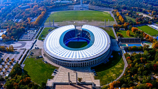 4K aerial drone view of Olympiastadion Berlin, 1936 Olympic Games venue, autumn foliage in Olympiapark, Berlin, Germany