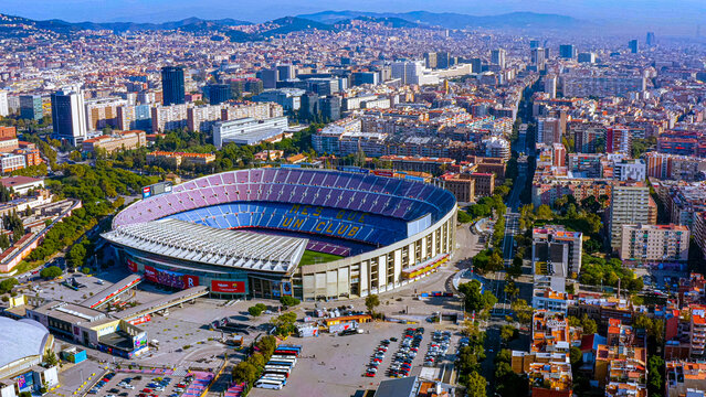 4K aerial drone view of Camp Nou stadium, FC Barcelona, Mes que un Club motto in seating, Barcelona cityscape, Spain. Pre-renovation Camp Nou before 2023. 