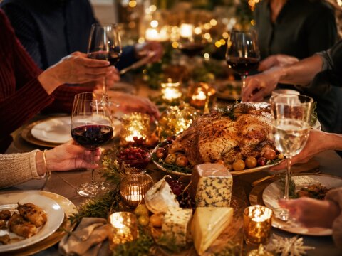 Franz&ouml;sischer R&eacute;veillon-Tisch mit gebratenem Gefl&uuml;gel, K&auml;se, Wein und Kerzen in warmer Weihnachtsatmosph&auml;re.