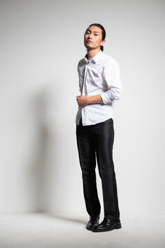 Studio portrait of an Asian man wearing a white shirt.