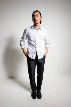 Studio portrait of an Asian man wearing a white shirt.