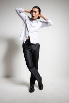 Studio portrait of an Asian man wearing a white shirt.