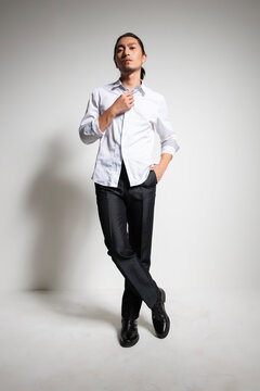 Studio portrait of an Asian man wearing a white shirt.