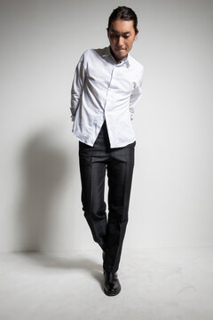 Studio portrait of an Asian man wearing a white shirt.