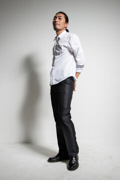 Studio portrait of an Asian man wearing a white shirt.