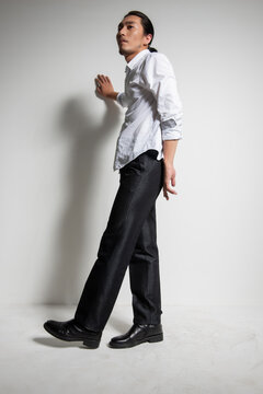 Studio portrait of an Asian man wearing a white shirt.
