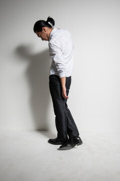 Studio portrait of an Asian man wearing a white shirt.