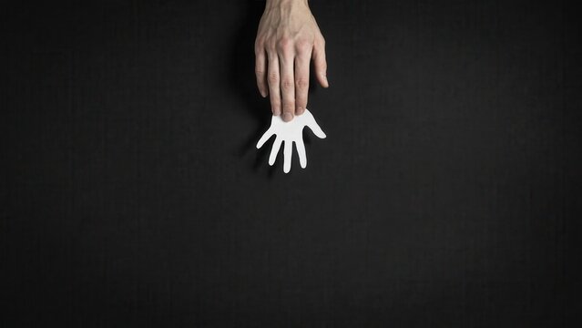 A hand dropping small white bird into dark space