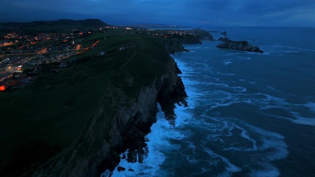Aerial drone flyby of dramatic sea cliffs and offshore rock formations in Santander Spain