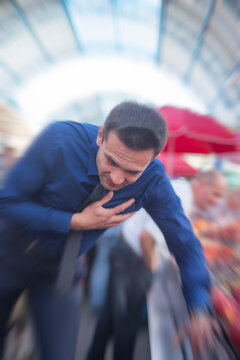 Fainting businessman falling down and losing balance during heart attack with copy space