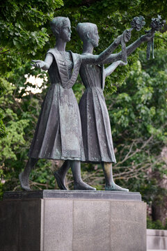 Bronze statue of two women holding bouquets of flowers as part of a public monument, Slavin Memorial, Bratislava, Slovakia, Europe.