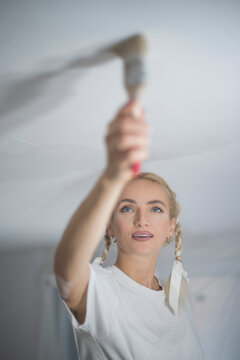  Cinematic portrait of focused young woman renovating home with copy space