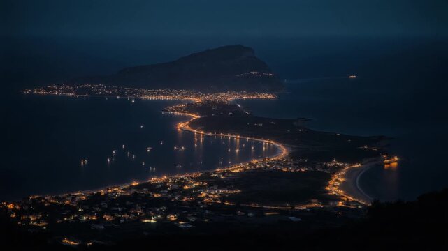 Aerial view of Capo Vaticano coastline and city lights at night