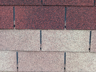 Fototapeta premium Detailed top-down view of overlapping asphalt roof shingles featuring a gritty, mineral-granule texture in various shades