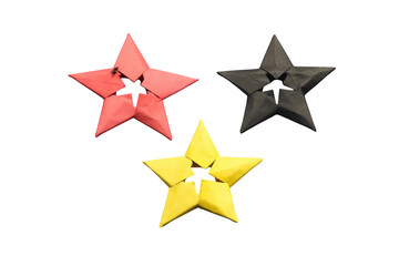 Obraz premium Origami stars in red yellow and black colors arranged in triangle formation on transparent grid background.