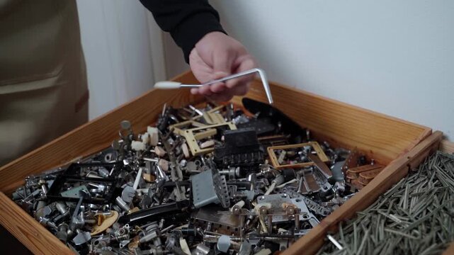 Guitar Technician Searching for Tremolo Arm Replacement Part in Workshop
