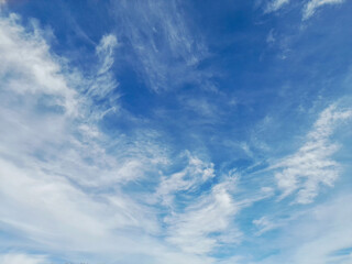 Obraz premium Beautiful wispy clouds scattered across a bright blue summer sky.
