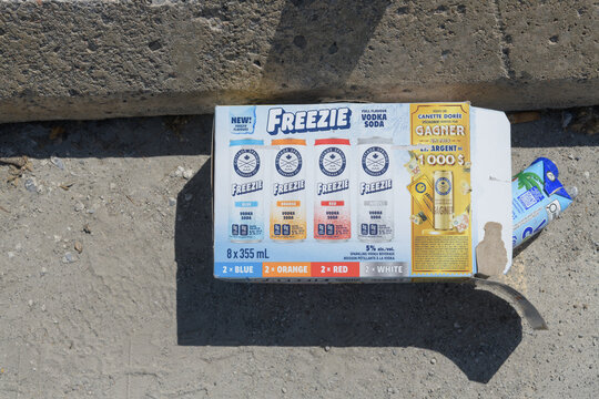 discarded package of Freezie vodka soda beverages on the ground in a parking lot, Toronto