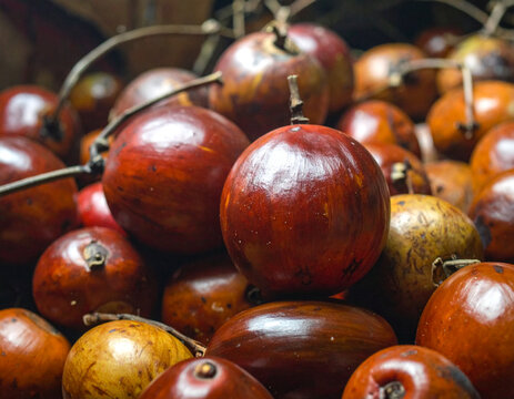 Tumpukan buah mamoncillo berwarna merah dan cokelat mengkilap