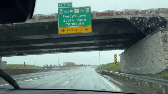 Experience the intensity of driving in heavy rain as the car navigates a bridge in Halifax, Nova Scotia, revealing the beauty and drama of nature's elements
