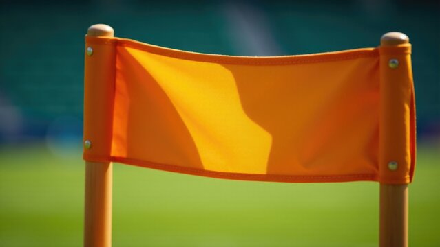 A single yellow flag sitting on a lush green grassy field, ideal for sports or event photography
