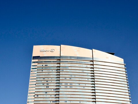 The modern skyscraper facade of the Hilton Fukuoka Sea Hawk hotel against a clear blue sky