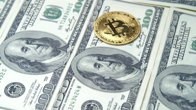Discover the fascinating world where cash meets cryptocurrency. Observe the golden Bitcoins harmonizing with hundred-dollar bills against a rich backdrop
