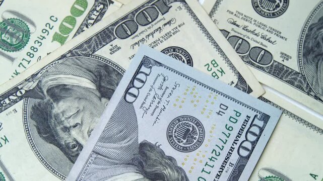 Bright hundred-dollar bills scattered across a surface bring a sense of luxury and abundance, highlighting the beauty of currency and its significance in everyday life