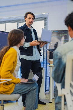 Diverse software developers team coding data software presentation on screen startup creative collaboration corporate marketing campaign tech cybersecurity hybrid workspace office background