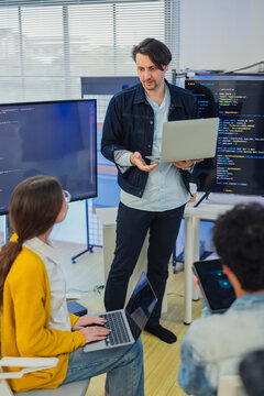 Diverse software developers team coding data software presentation on screen startup creative collaboration corporate marketing campaign tech cybersecurity hybrid workspace office background