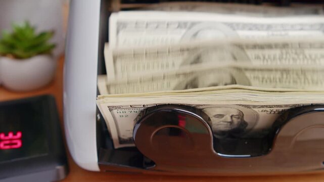 A cash counting machine effortlessly sorts bills while a gentle hum fills the air. Sunlight streams in as each note is neatly arranged, showcasing efficiency in action