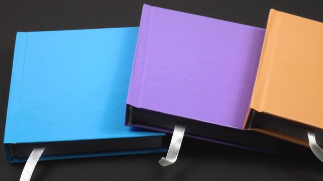 Notepads with colorful binding   lie on a black table