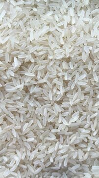 Vertical camera flyover above raw white rice grains macro texture