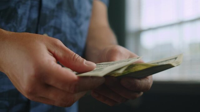 In a warm, inviting space, hands carefully sort through a stack of bills. The afternoon sunlight streams through, highlighting the financial activity taking place