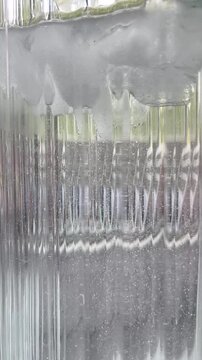 Clear ice cubes floating in glass of water macro video