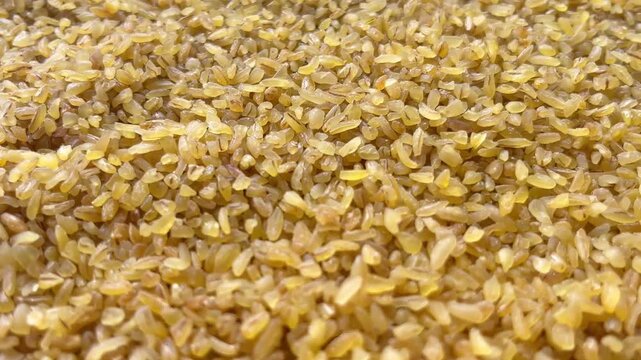Horizontal camera flyover above raw bulgur wheat groats macro texture