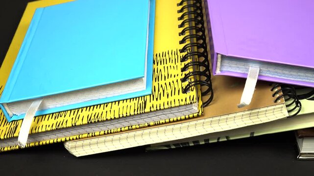 Various types of notepads lie on a black table. Objects for notations, studying, note -taking, and diary.