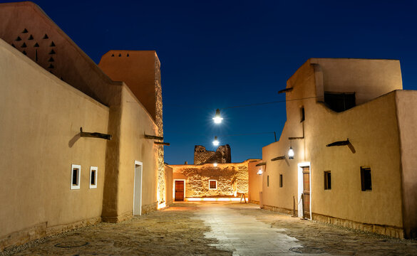 Illuminated traditional mud brick buildings in the historic district of At-Turaif in Diriyah, Saudi Arabia at night