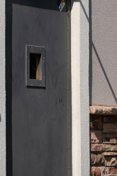 Closed grey door with a small rectangle glass window.