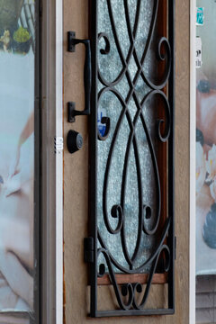 Decorative iron door with a textured glass piece in the center.
