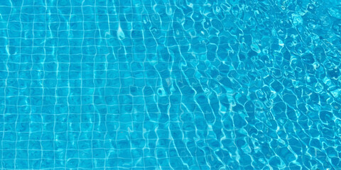 Obraz premium A crystal clear turquoise swimming pool water surface creates a cool and refreshing abstract ripple pattern with gentle blue waves reflecting the bright summer sunlight