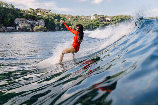 Surfer woman fell off a swell wave. Surf girl wipe out during surfing in Bali