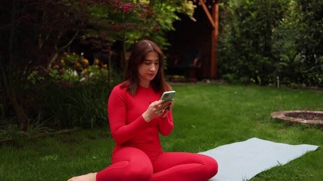 Vertical screen Young woman reaches for her smartphone during meditation showing how digital habits interrupt mindfulness and pull attention away from the present moment
