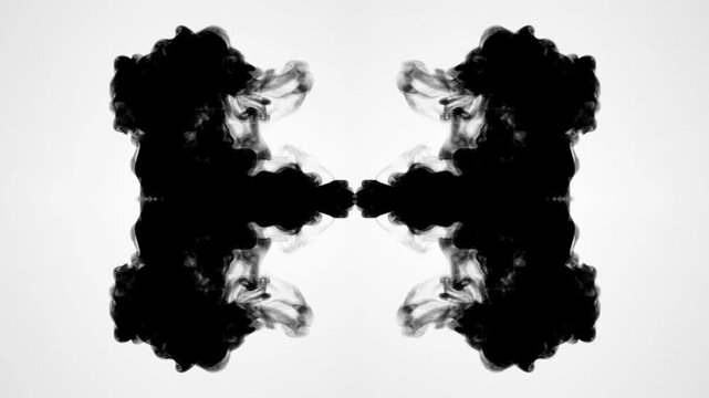 An abstract, slow-motion video showing black ink expanding symmetrically in water against a clean white background. creating beautiful fluid textures and organic, Rorschach-like patterns