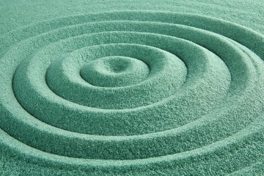 Concentric sand rings arranged on textured zen garden surface